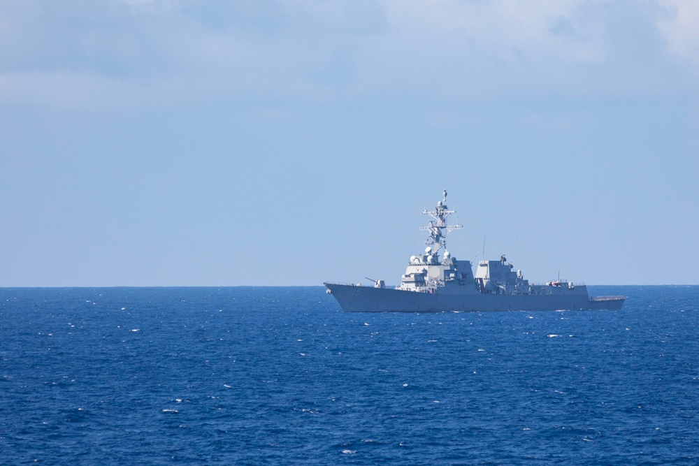 USS Rafael Peralta steams past the USS Ralph Johnson in the South China Sea.