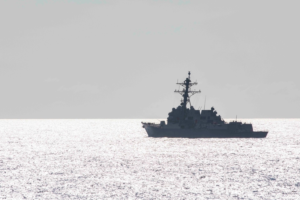 USS Rafael Peralta steams past the USS Ralph Johnson in the South China Sea.