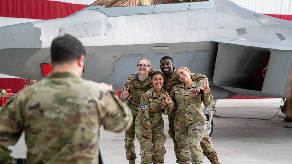 U.S. Air Force Airmen pose in front of an F-22 Raptor during Air Force Bash at Hangar 3 at Joint Base Elmendorf-Richardson, Alaska, Sept. 22, 2023.