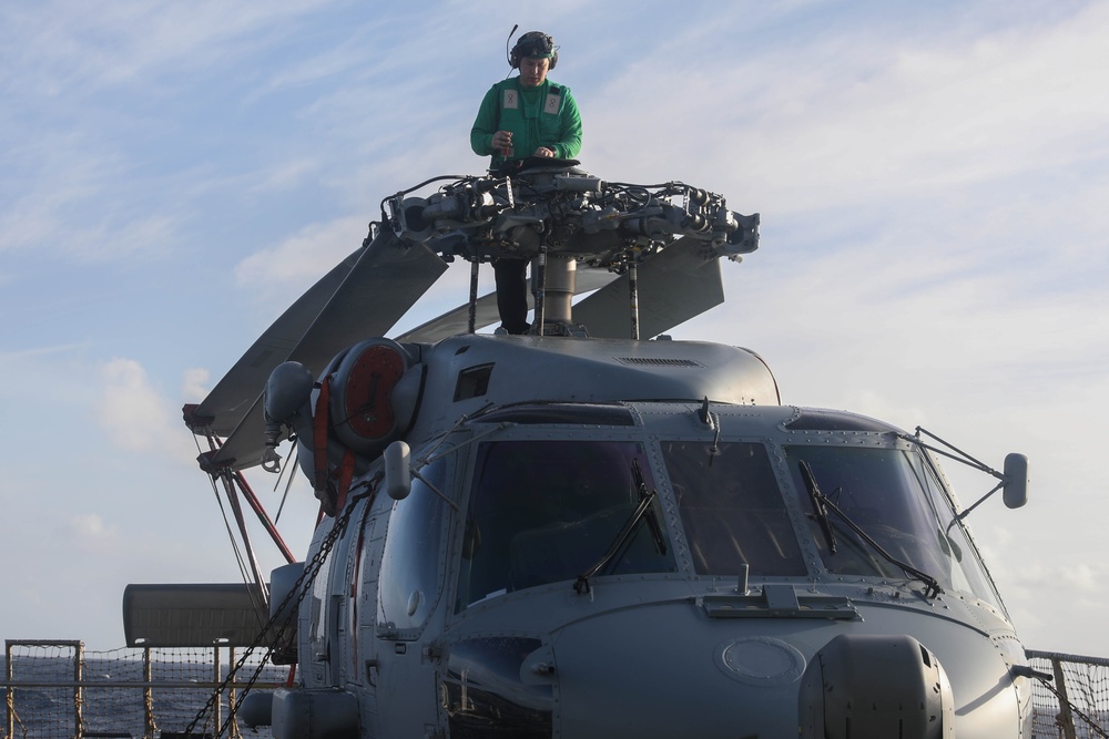 Aviation Electrician’s Mate Petty Officer 2nd Class Austin Goodrich conducts routine maintenance on a Sea Hawk helicopter (MH-60R) aboard the USS Rafael Peralta (DDG 115)