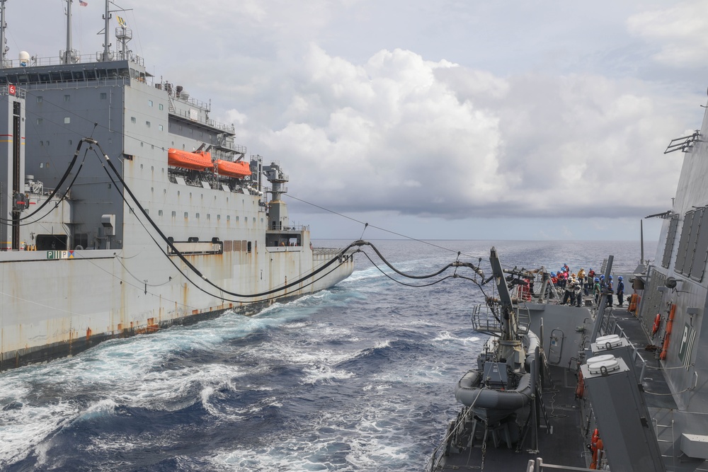 Sailors aboard the Arleigh Burke-class guided-missile destroyer USS Rafael Peralta (DDG 115) conduct a replenishment at sea with the Lewis and Clark-class dry cargo USNS Wally Schirra (T-AKE-8) in the South China Sea