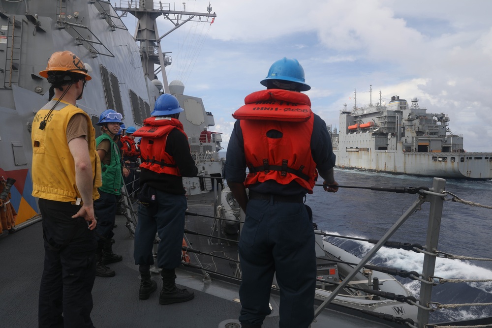 Sailors aboard the Arleigh Burke-class guided-missile destroyer USS Rafael Peralta (DDG 115) conduct a replenishment at sea with the Lewis and Clark-class dry cargo USNS Wally Schirra (T-AKE-8) in the South China Sea