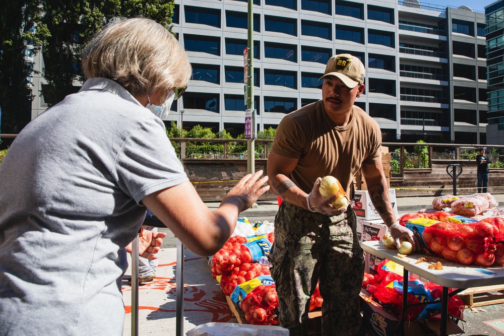 U.S. Navy Sailors distribute food to the local community during San Francisco Fleet Week