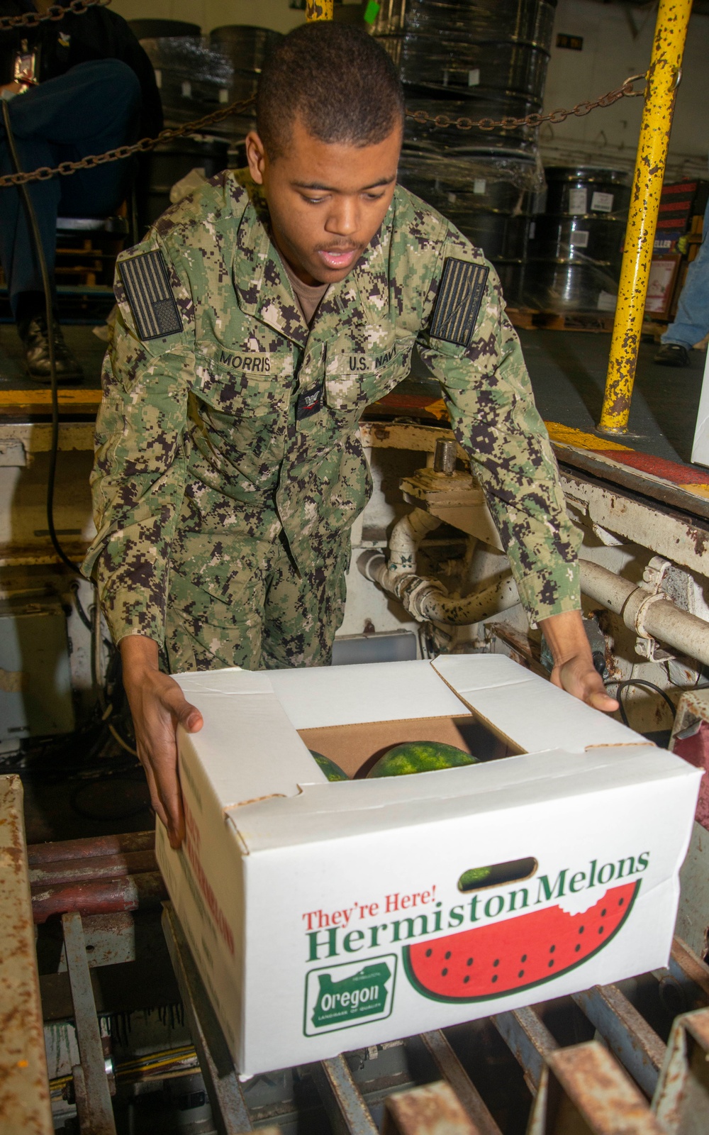 Sailor Loads Cargo Onto Conveyer