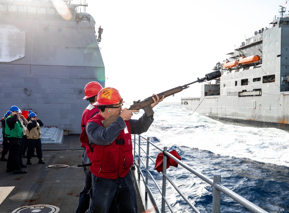 USS Robert Smalls (CG 62) Sailor Shoots Shot line during RAS with USNS Charles Drew (T-AKE 10)