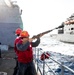 USS Robert Smalls (CG 62) Sailor Shoots Shot line during RAS with USNS Charles Drew (T-AKE 10)