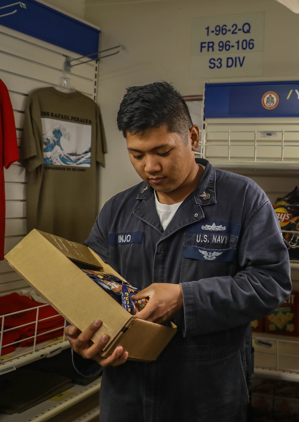 Retail Services Specialists restock the ship’s store aboard the Arleigh Burke-class guided-missile destroyer USS Rafael Peralta (DDG 115) in the Philippine Sea