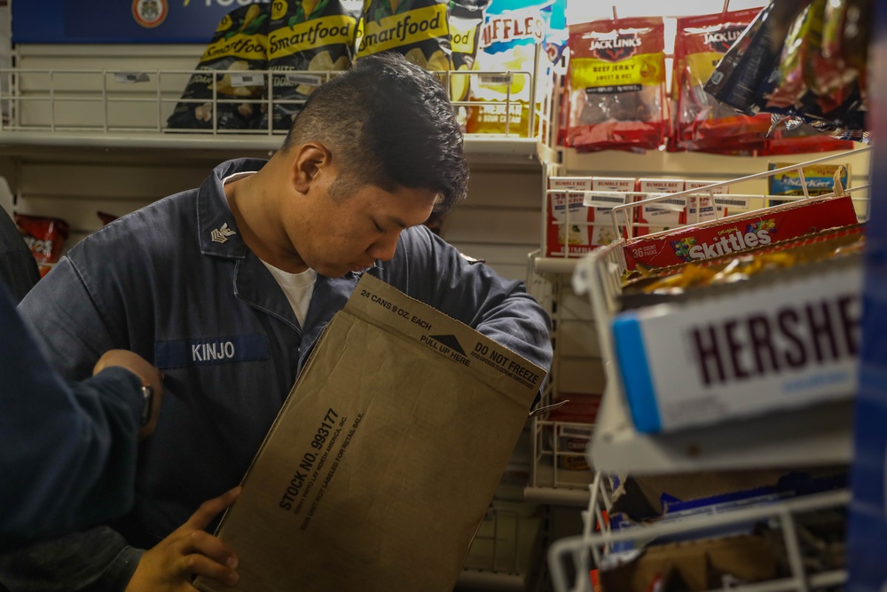 Retail Services Specialists restock the ship’s store aboard the Arleigh Burke-class guided-missile destroyer USS Rafael Peralta (DDG 115) in the Philippine Sea