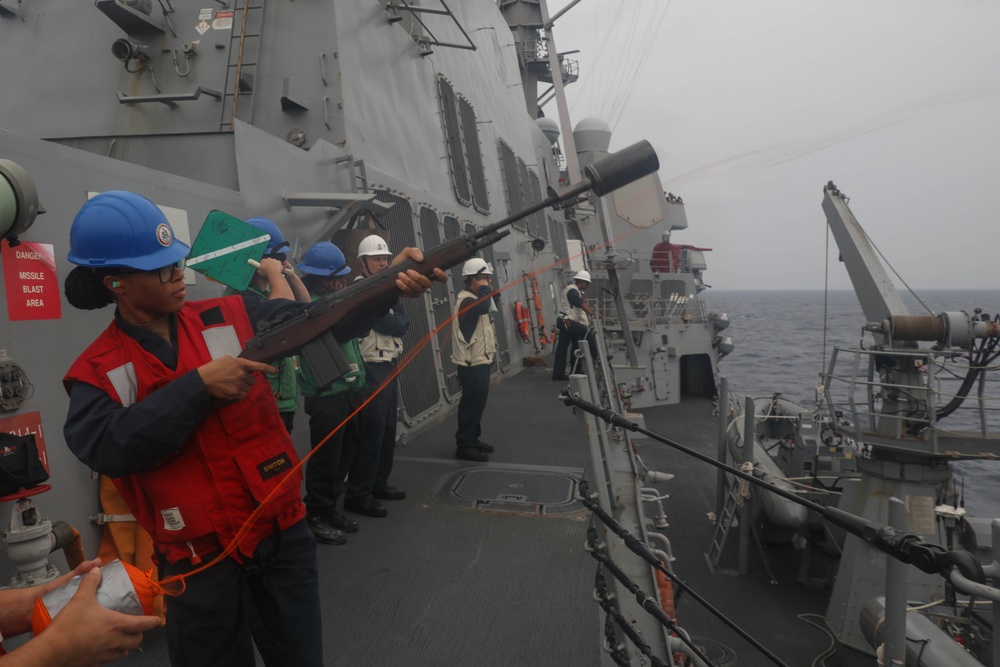 Sailors aboard the USS Rafael Peralta (DDG 115) conducts a replenishment-at-sea with Royal Canadian Navy supply ship MV Asterix in the South China Sea