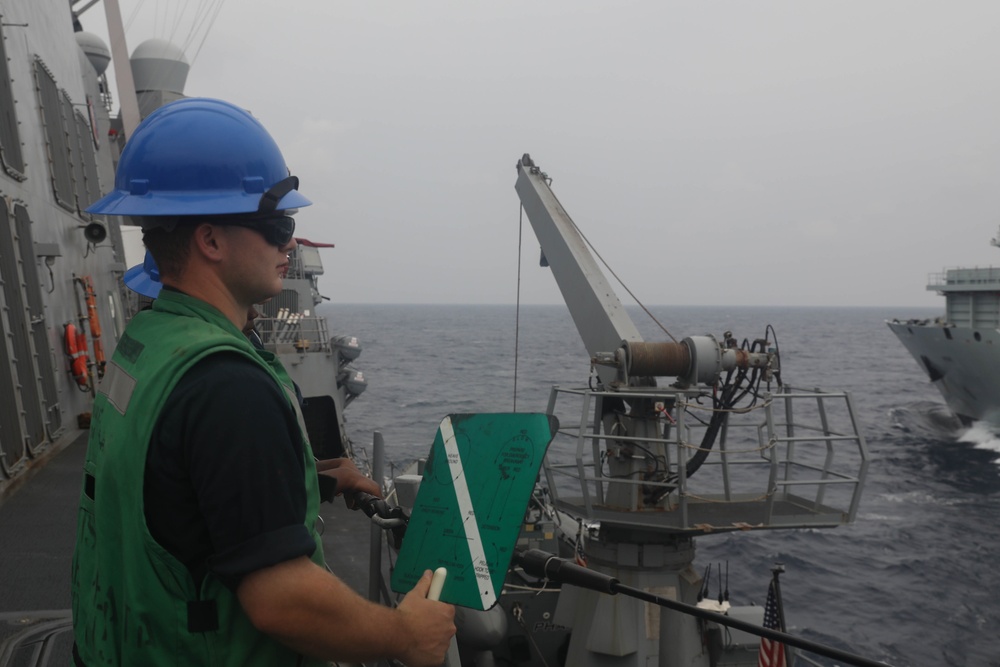 Sailors aboard the USS Rafael Peralta (DDG 115) conducts a replenishment-at-sea with Royal Canadian Navy supply ship MV Asterix in the South China Sea