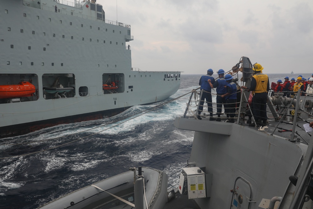 Sailors aboard the USS Rafael Peralta (DDG 115) conducts a replenishment-at-sea with Royal Canadian Navy supply ship MV Asterix in the South China Sea