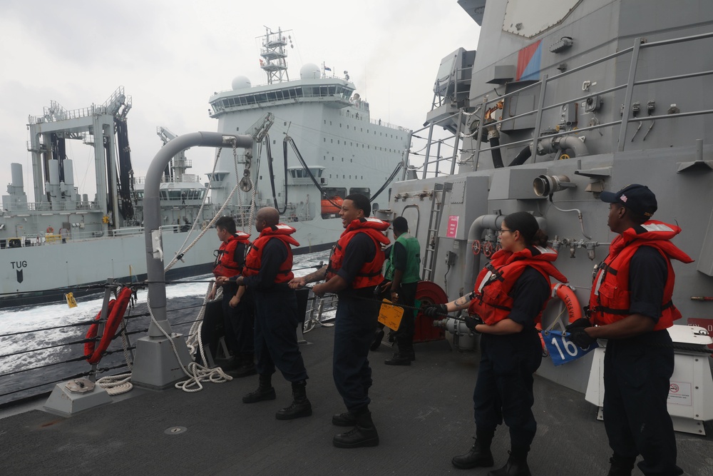 Sailors aboard the USS Rafael Peralta (DDG 115) conducts a replenishment-at-sea with Royal Canadian Navy supply ship MV Asterix in the South China Sea