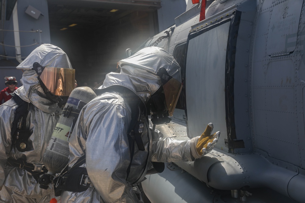 Sailors aboard the USS Rafael Peralta (DDG 115) conduct a crash and salvage drill