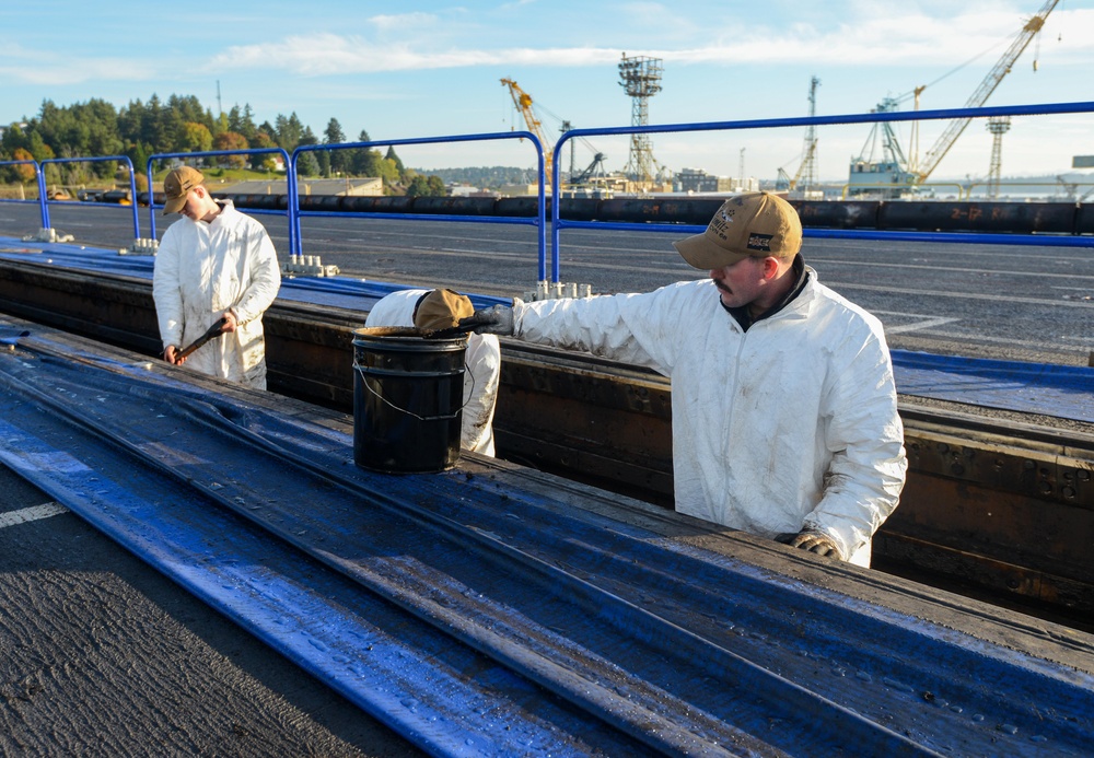 U.S. Navy Sailors Clean Catapult Trough