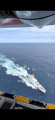 U.S. Coast Guard HC-130 flies above the USCGC Terrell Horne