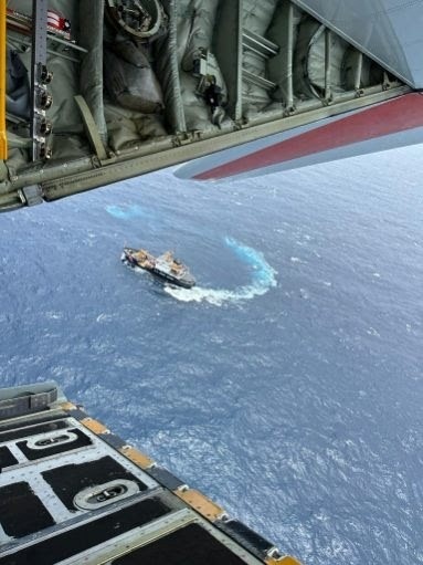 U.S. Coast Guard HC-130 flies above the USCGC Alder