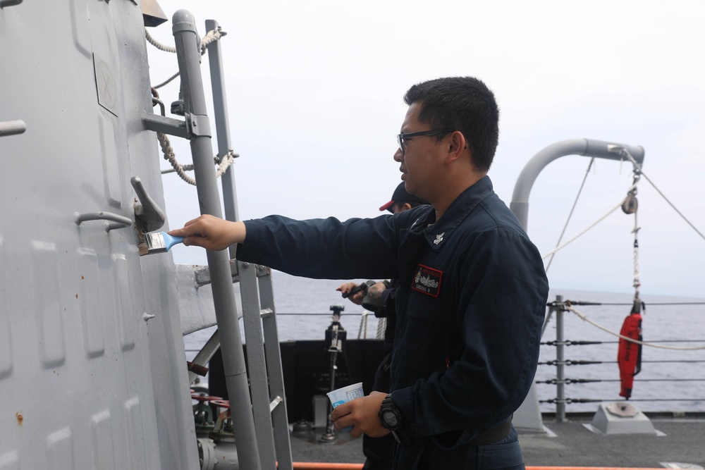 Sailors aboard the USS Rafael Peralta (DDG 115) conduct a freshwater wash down in the South China Sea