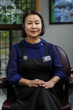 Ms. Yu Jeom Nam washes a customer's hair after providing a haircut at U.S. Army Garrison Yongsan's Barbershop, Oct. 4.