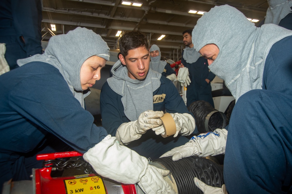 USS Ronald Reagan (CVN 76) Sailors simulate firefighting during general quarters drill