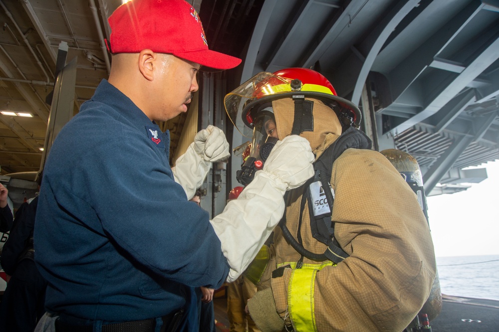 USS Ronald Reagan (CVN 76) Sailors simulate firefighting during general quarters drill