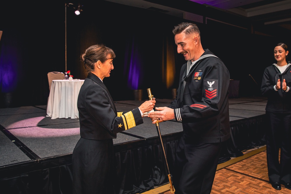 U.S. Navy Sailor presents the first slice of cake