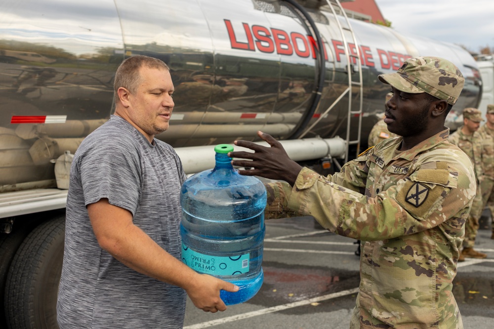 The 10th Mountain Division Sustainment Brigade help distribute water outside of the Watertown Municipal Arena to residents of Watertown, New York.