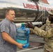 The 10th Mountain Division Sustainment Brigade help distribute water outside of the Watertown Municipal Arena to residents of Watertown, New York.