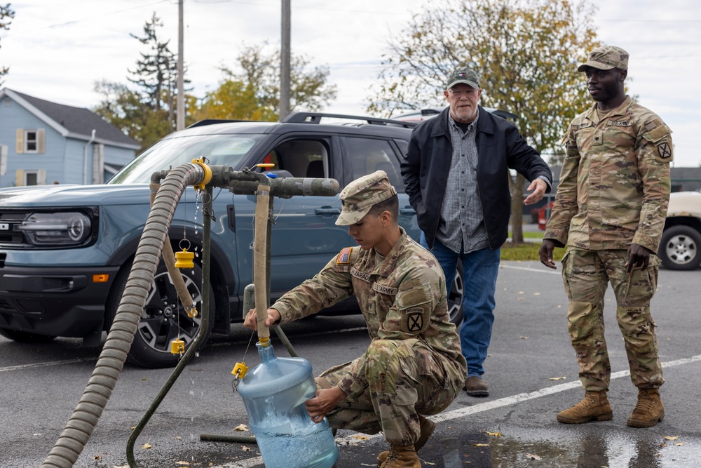 The 10th Mountain Division Sustainment Brigade help distribute water outside of the Watertown Municipal Arena to residents of Watertown, New York.