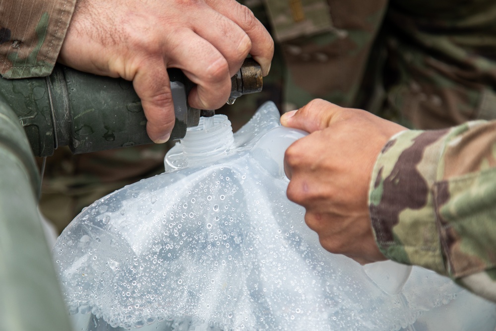 The 10th Mountain Division Sustainment Brigade 548th Combat Sustainment Support Battalion help distribute water outside of the Watertown Municipal Arena to residents of Watertown, New York.