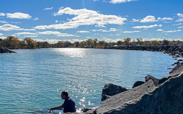 Fisherman casts line from harbor breakwall