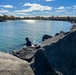 Fisherman casts line from harbor breakwall