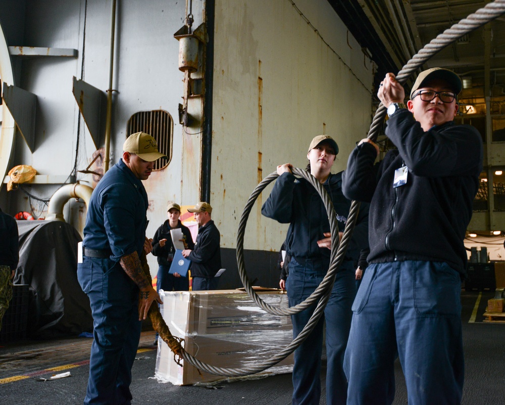 U.S. Navy Sailors Move Equipment Into Hangar Bay