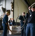 U.S. Navy Sailors Move Equipment Into Hangar Bay