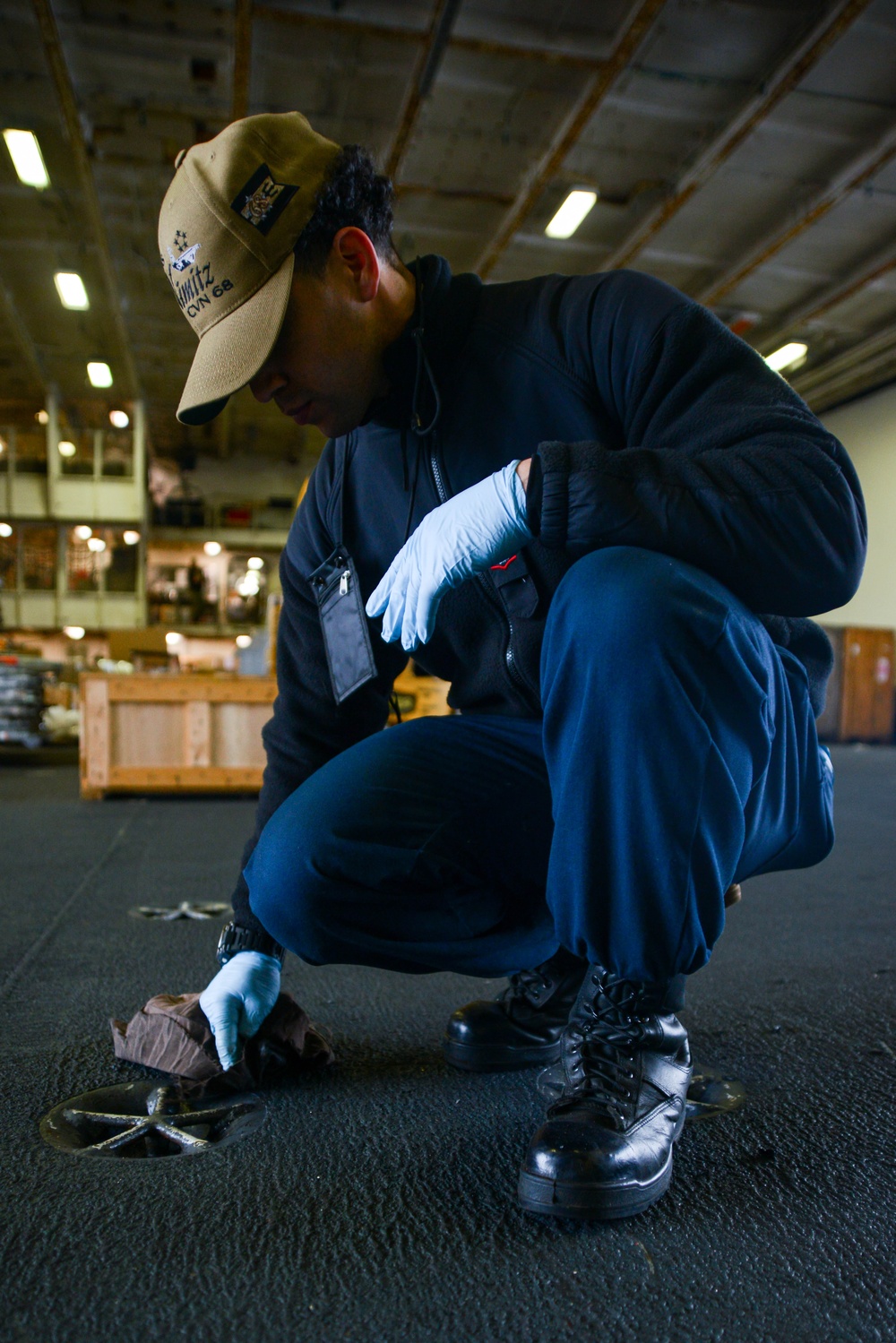 U.S. Navy Sailor Clears Pad Eyes Of Debris