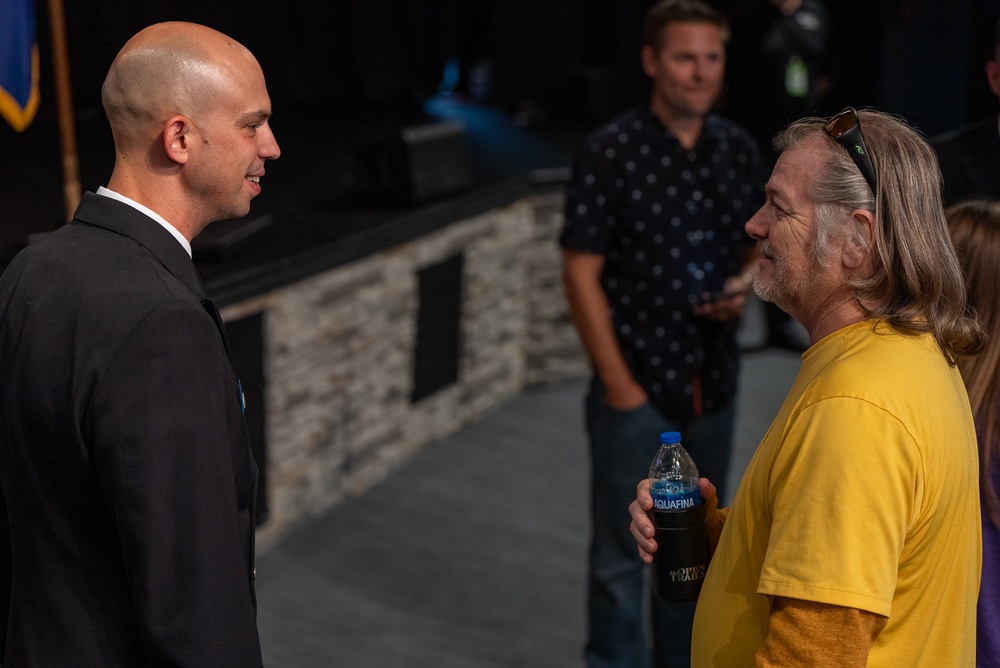 Chief Musician Jonathan Barnes speaks with a concert goer at Pace Assembly of God Church