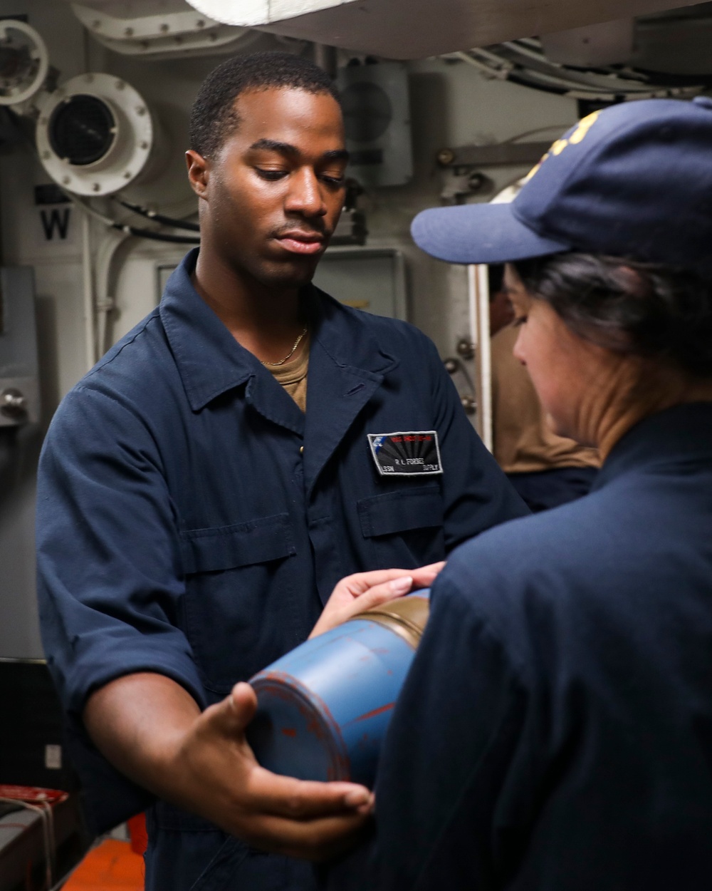 Sailors aboard USS Shoup conduct ammunition movement