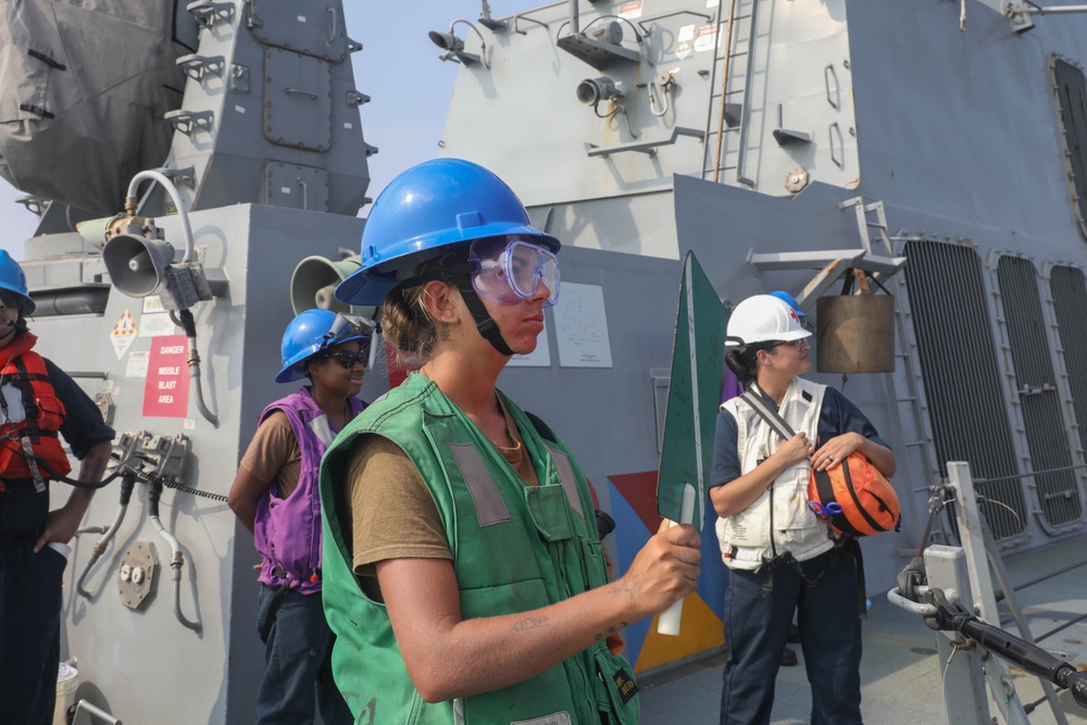 Sailors aboard the USS Rafael Peralta (DDG 115) conduct a replenishment-at-sea with the Lewis and Clark-class dry cargo USNS Wally Schirra (T-AKE-8) in the South China Sea