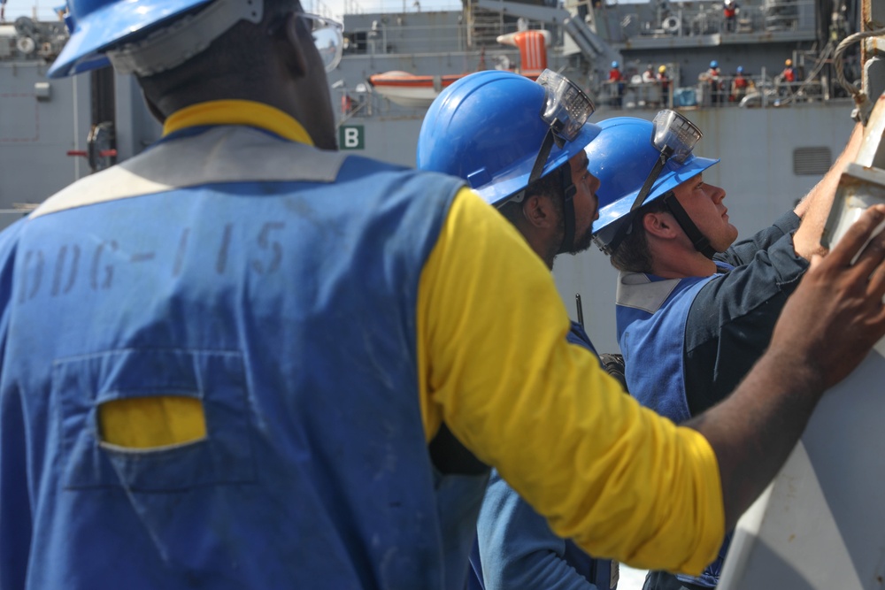 Sailors aboard the USS Rafael Peralta (DDG 115) conduct a replenishment-at-sea with the Lewis and Clark-class dry cargo USNS Wally Schirra (T-AKE-8) in the South China Sea