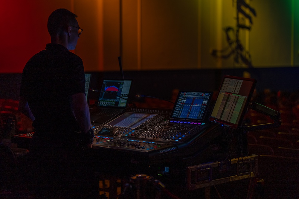 Musician 1st Class David Angell mixes on the sound board while performing at Howard Middle School Academy of Arts.