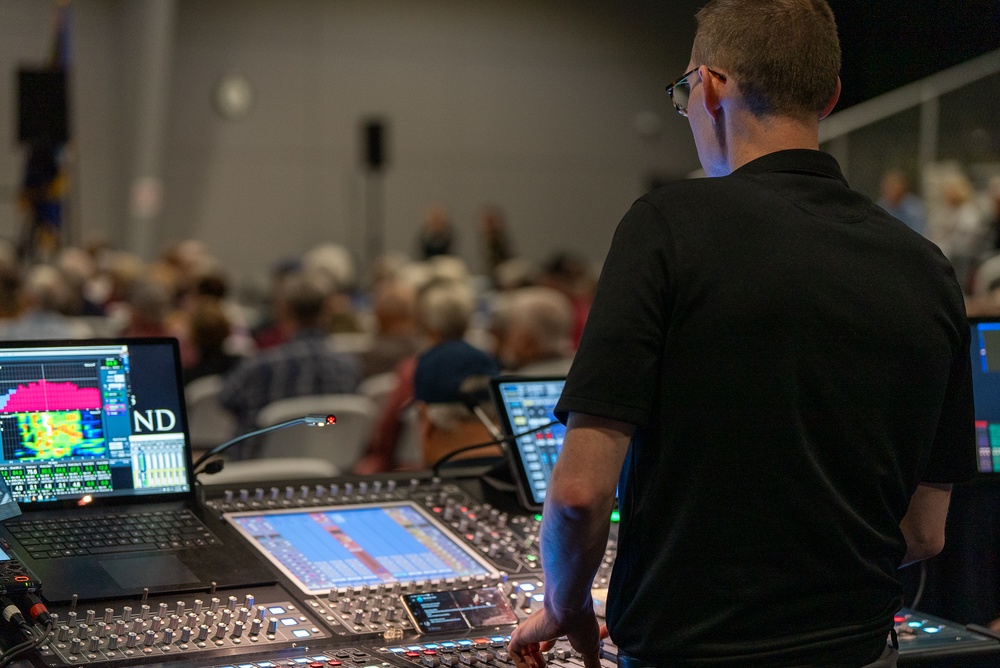 Musician 1st Class David Angell mans the sound board at the MetroHealth Stadium