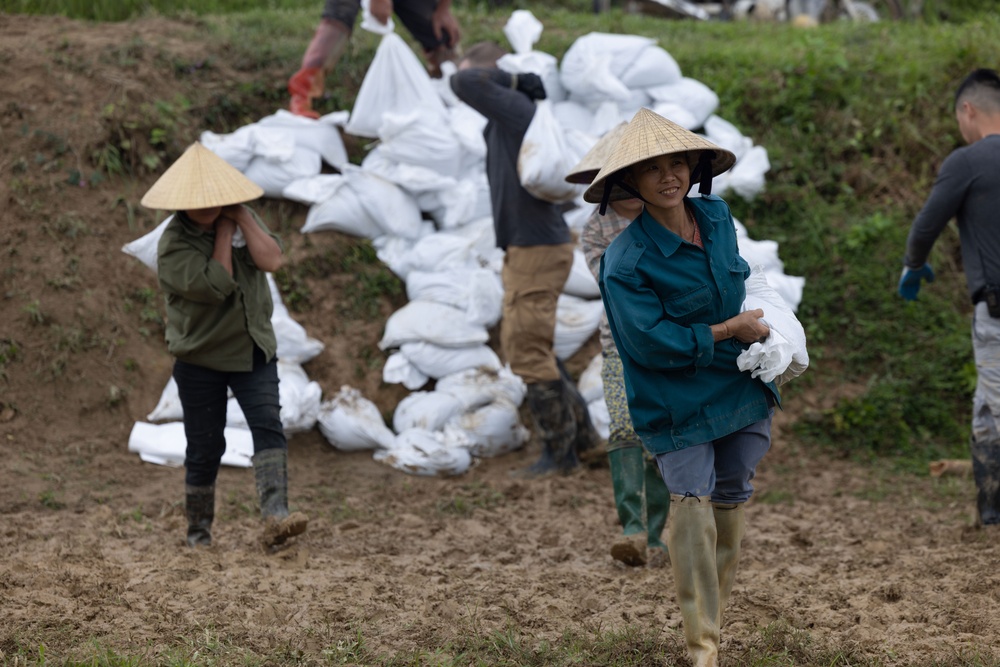 DPAA and Vietnamese locals build a cofferdam