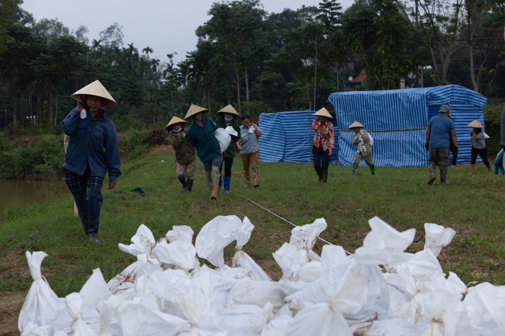 DPAA and Vietnamese locals build a cofferdam