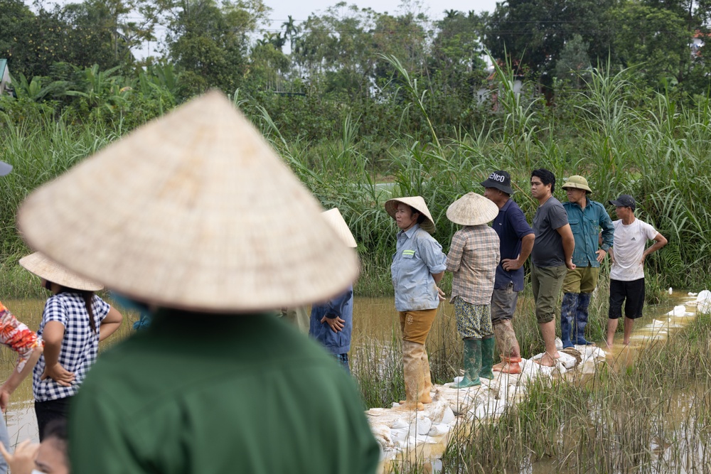 DPAA and Vietnamese locals build a cofferdam