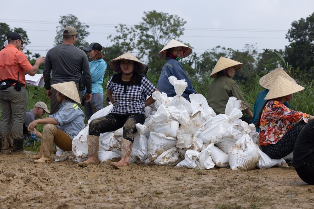 DPAA and Vietnamese locals build a cofferdam