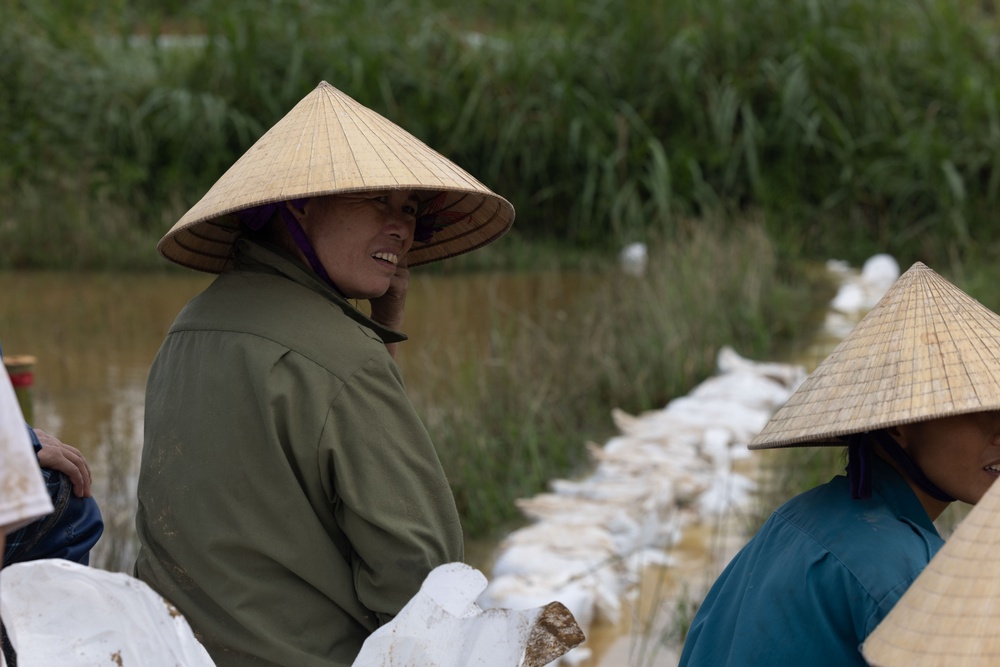 DPAA and Vietnamese locals build a cofferdam