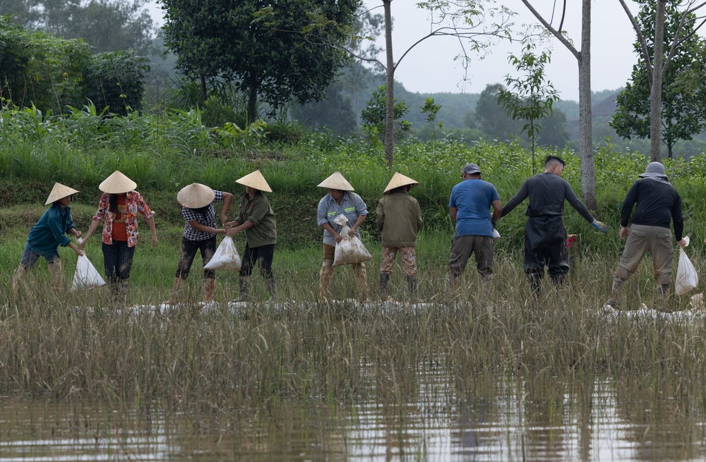 DPAA and Vietnamese locals build a cofferdam