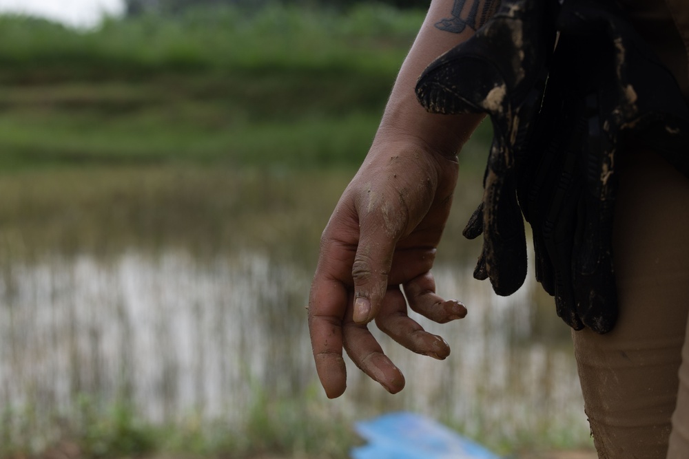 DPAA and Vietnamese locals build a cofferdam