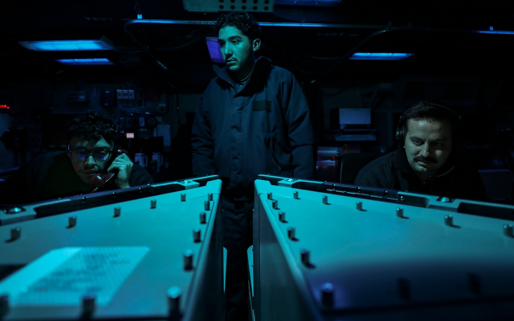 Sailors aboard USS Shoup stand watch in combat information center