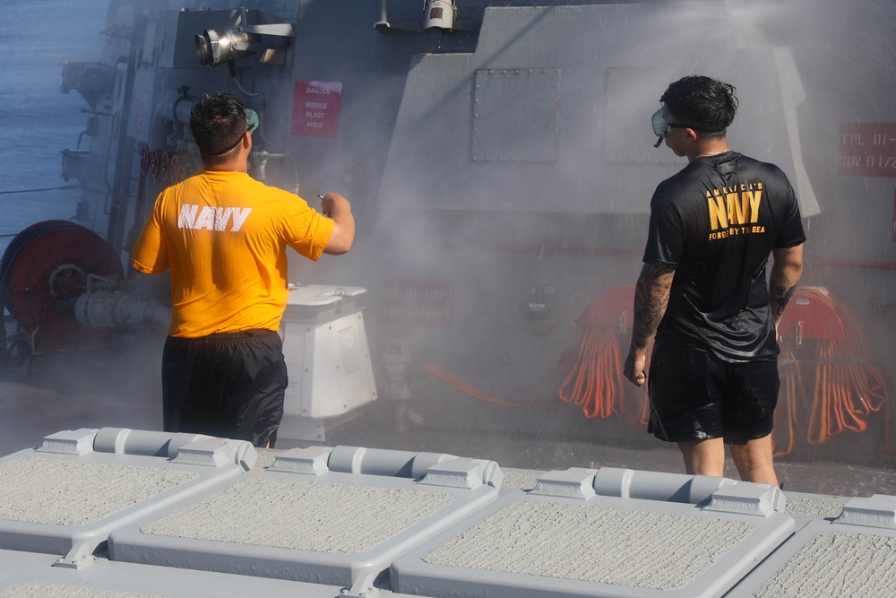 Sailors aboard the USS Rafael Peralta (DDG 115) conduct a countermeasure wash down in the East China Sea