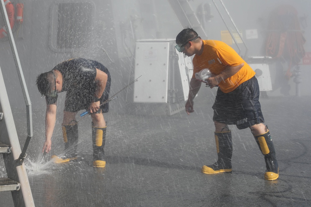 Sailors aboard the USS Rafael Peralta (DDG 115) conduct a countermeasure wash down in the East China Sea